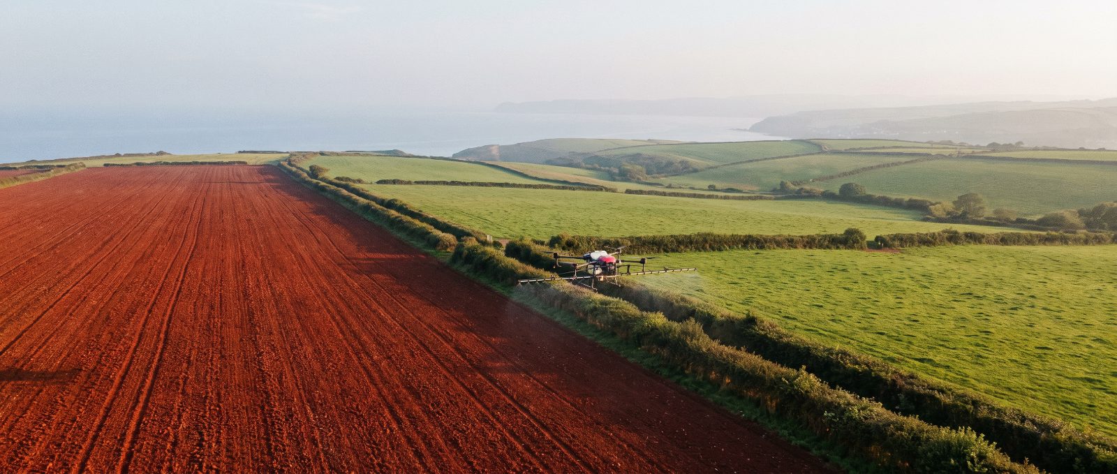 Agricultural spray drone working over South West farmland