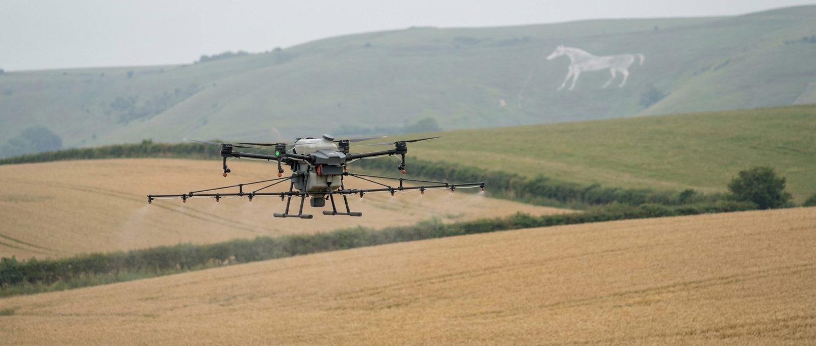 Agricultural spray drone working over Wiltshire farmland